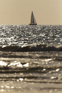 Sailboat in sea against sky