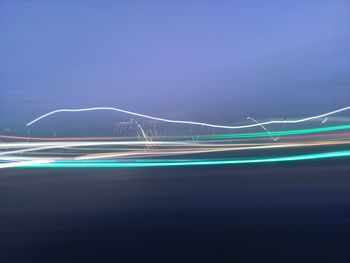 Light trails against blue sky at night