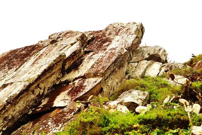 Low angle view of rocks against clear sky