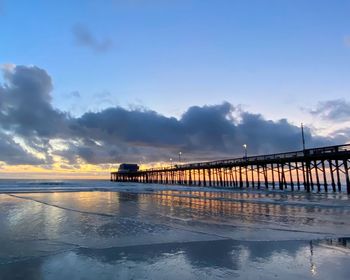 Bridge over sea against sky during sunset