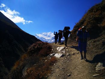 People walking on mountain against sky