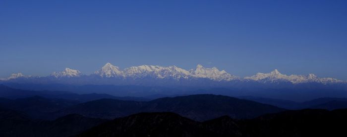 Scenic view of mountains against clear blue sky