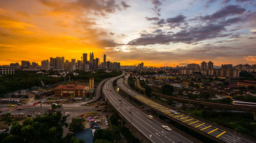 High angle view of street amidst buildings against sky during sunset