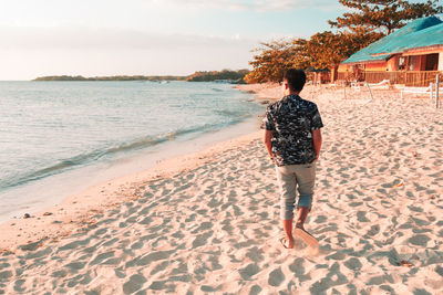 Rear view of man standing on beach