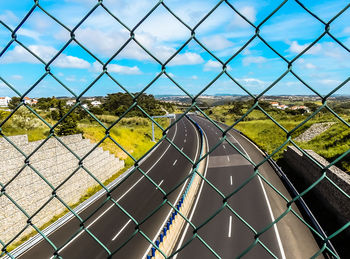 Close-up of chainlink fence against blue sky