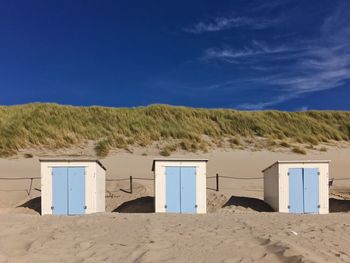 Built structure on beach against blue sky