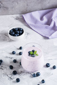 A glass of blueberry smoothie on the table. antioxidant organic healthy food. vertical view