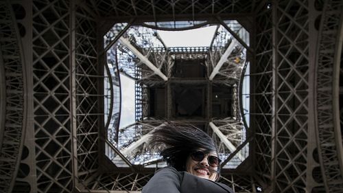 Directly below portrait of young woman under eiffel tower