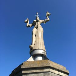 Low angle view of statue against clear blue sky