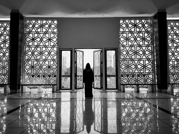 Rear view of silhouette woman standing in building