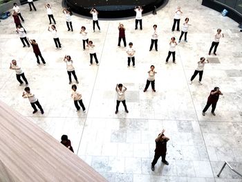 High angle view of people walking on tiled floor