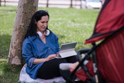 Young woman using laptop while sitting on chair