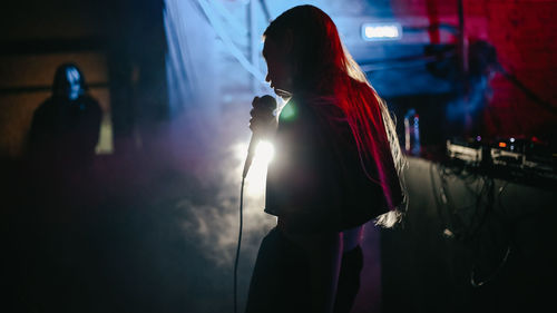 Midsection of women standing in illuminated nightclub