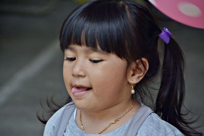 Close-up of girl sticking out tongue