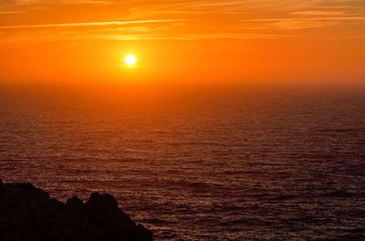 Scenic view of sea against orange sky