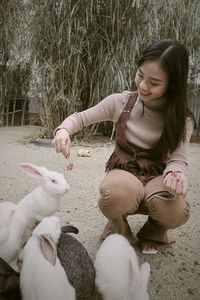 High angle view of woman with lamb on field