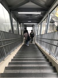 Rear view of people walking on staircase