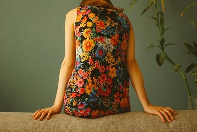 Rear view of woman sitting on sofa at home