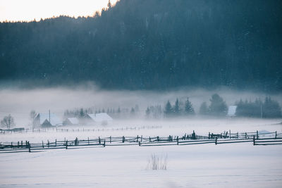 Panoramic view of frozen lake against sky during foggy weather