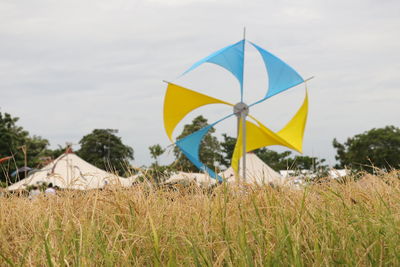 Umbrellas on field against sky