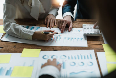 Midsection of business colleagues working on table