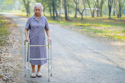 Full length portrait of woman standing on walkway