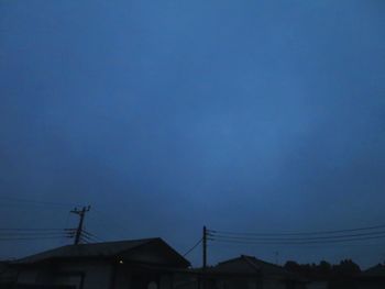 Low angle view of silhouette house against sky