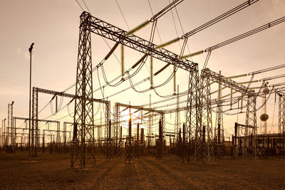 Low angle view of electric power substation during sunset