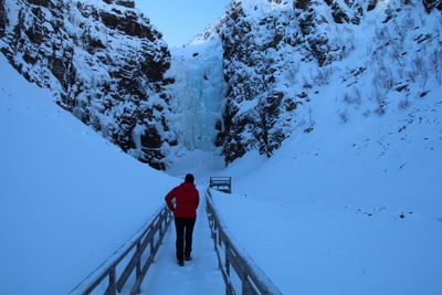 Rear view of man on snow covered mountain