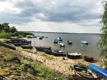 Boats moored in lake against sky