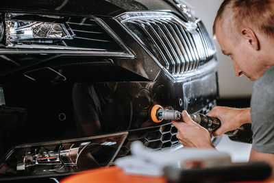 Side view of man repairing car