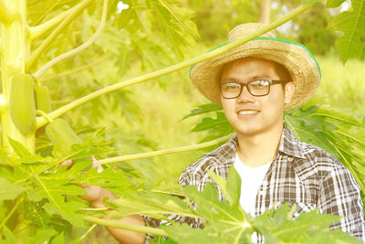 Portrait of young man with papaya plant