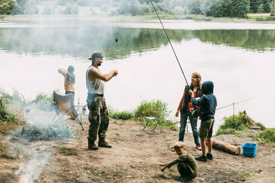 A happy family is fishing on the bank of a river or lake. spending time together, family time