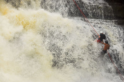 People climbing up waterefall