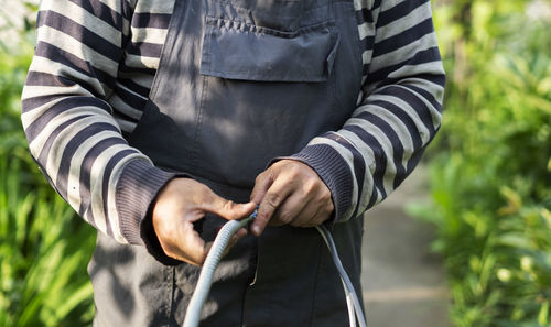 Adult caucasian male pulls cable through metal protective sleeve.