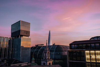 Modern buildings against sky during sunset