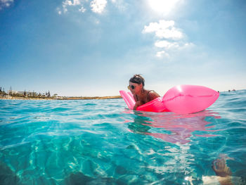 Person in swimming pool against sea