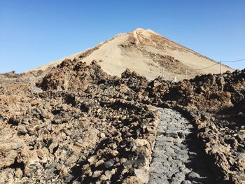 Mountain at desert against clear blue sky