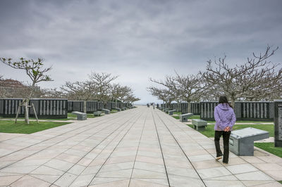 Woman walking on footpath in city