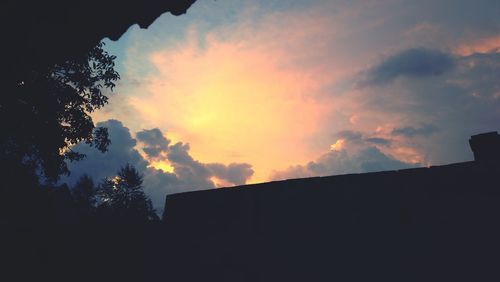 Silhouette of building against sky at sunset