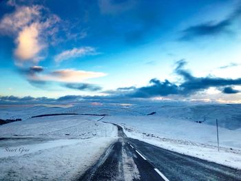 Scenic view of snow covered road against sky