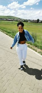 Portrait of young woman walking on road