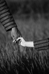 Parent and child holding hands on land