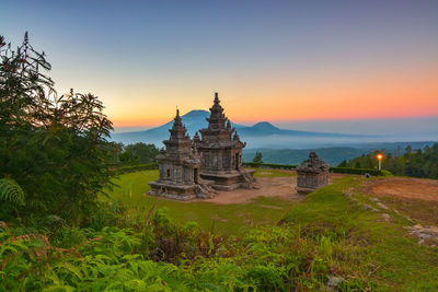 Temple in building against sky during sunset