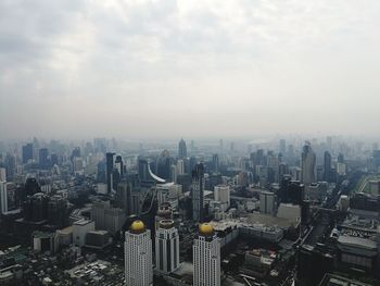 Aerial view of buildings in city against sky