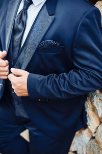 Midsection of man holding umbrella