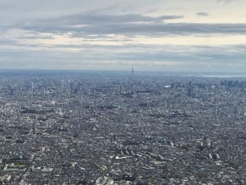 Aerial view of city against cloudy sky