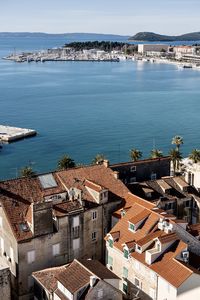 High angle view of townscape by sea against sky