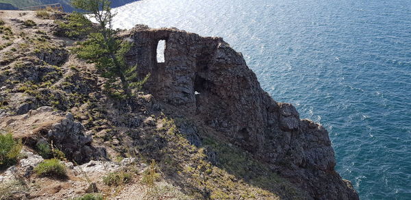 Rock formations by sea against sky