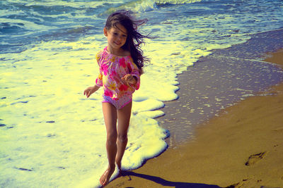Full length of happy girl standing on beach